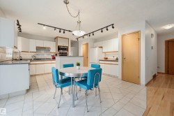 White cabinetry kitchen with tile flooring and a built-in oven - 