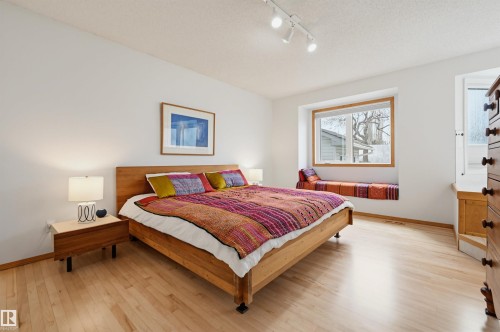 Light wood-finish flooring complements white walls - 317 Hollick-Kenyon Road, Edmonton, AB - Indoor Photo Showing Bedroom