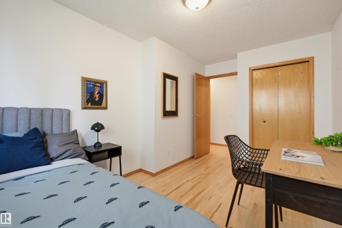 Room featuring wood-finish flooring, a wood-finish bi-fold closet, and a light wood-finish door frame - 317 Hollick-Kenyon Road, Edmonton, AB - Indoor Photo Showing Bedroom