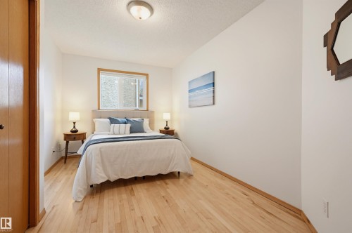 Bedroom featuring light wood-finish flooring, white walls, and a window with a light wood-finish frame - 317 Hollick-Kenyon Road, Edmonton, AB - Indoor Photo Showing Bedroom