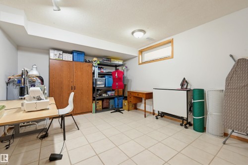 Lower-level room with tiled flooring, white painted walls, and a recessed window with wood trim - 317 Hollick-Kenyon Road, Edmonton, AB - Indoor