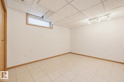 Room featuring tile flooring and a drop ceiling with integrated track lighting - 