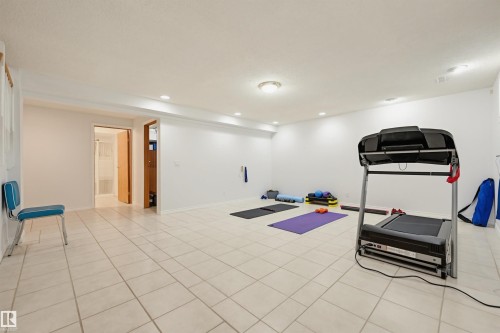 Spacious room featuring white tile flooring, recessed lighting, and a neutral color palette - 317 Hollick-Kenyon Road, Edmonton, AB - Indoor Photo Showing Gym Room
