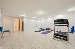 Spacious room featuring white tile flooring, recessed lighting, and a neutral color palette - 