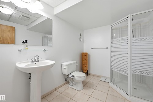 Bathroom with light-toned floor tiles and a white pedestal sink - 317 Hollick-Kenyon Road, Edmonton, AB - Indoor Photo Showing Bathroom