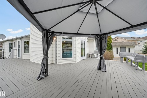 Expansive outdoor deck featuring a gray finish, white siding exterior, multiple windows, and a built-in privacy screen - 317 Hollick-Kenyon Road, Edmonton, AB - Outdoor With Deck Patio Veranda With Exterior