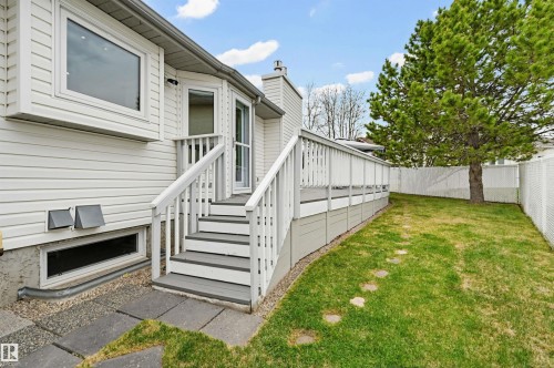 Rear exterior with white siding, showcasing a multi-level deck with white railings and steps - 317 Hollick-Kenyon Road, Edmonton, AB - Outdoor