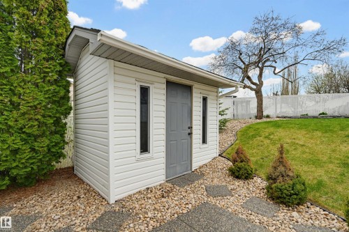 Detached outbuilding with white siding and gray door - 317 Hollick-Kenyon Road, Edmonton, AB - Outdoor