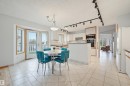 Kitchen with light-toned tiled flooring, white cabinetry, a built-in double oven, and track lighting - 317 Hollick-Kenyon Road, Edmonton, AB  - Indoor Photo Showing Dining Room 