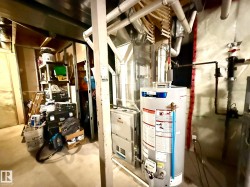 PHOTO OF THE BASEMENT FURNACE ROOM WITH A NEWER H.E. FURNACE & HWT! - 