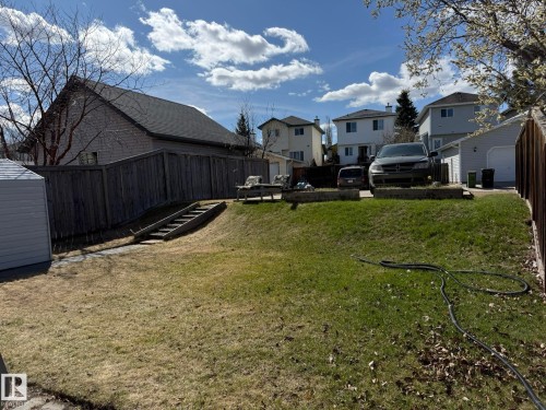 Expansive backyard featuring a sloped lawn and mature perimeter fencing - 645 Windross Crescent, Edmonton, AB 