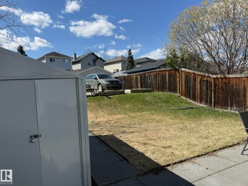 Expansive backyard featuring a partial patio, a storage shed, and a privacy fence - 645 Windross Crescent, Edmonton, AB 