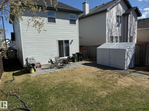Rear exterior featuring light-colored siding and a dark shingle roof - 645 Windross Crescent, Edmonton, AB 