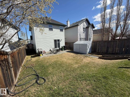 Rear exterior featuring horizontal siding, a patio area with pavers, and a sliding glass door - 645 Windross Crescent, Edmonton, AB 