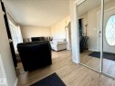 Entryway featuring a full-length mirrored closet door and a paneled front door with decorative oval glass - 645 Windross Crescent, Edmonton, AB 