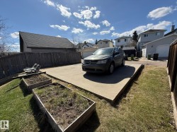 ANOTHER PHOTO OF THE LARGE PARKING PAD & THE RAISED GARDEN BEDS FOR YOUR SUMMERTIME GROWING SEASON! - 