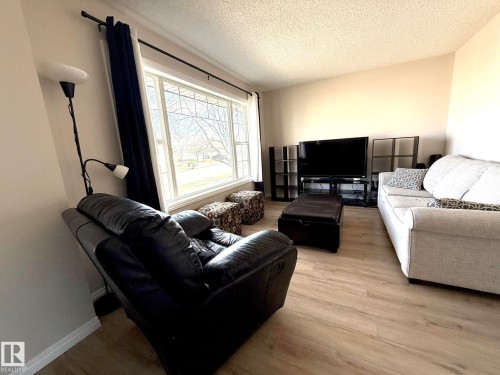 Living area featuring wood-finish flooring and light-toned walls - 645 Windross Crescent, Edmonton, AB 