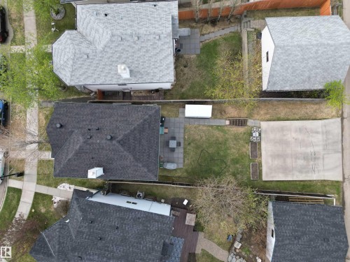 Aerial perspective showcasing a property with a dark shingle roof, a paved patio area, and a large concrete pad - 645 Windross Crescent, Edmonton, AB 