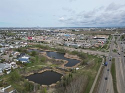 Aerial perspective showcasing residential properties, multiple bodies of water, and surrounding commercial areas - 