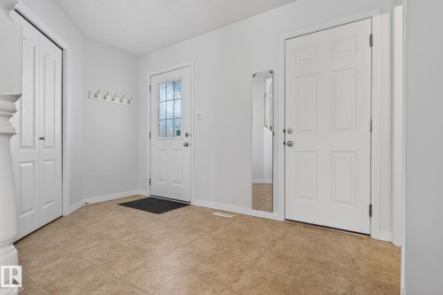 Entryway featuring durable tile flooring, a paneled entry door with frosted glass, and a second paneled door - 421 84 Street, Edmonton, AB - Indoor Photo Showing Other Room
