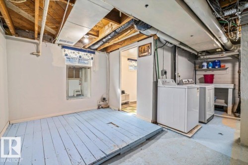 Basement utility area featuring exposed joists, a window opening, concrete flooring, and a dedicated laundry space with shelving - 10939 96 Street, Edmonton, AB - Indoor Photo Showing Laundry Room