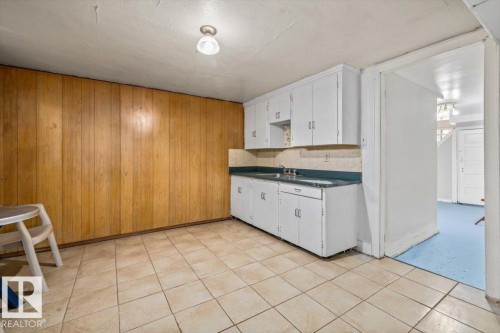 Kitchenette featuring white cabinetry with brushed nickel hardware, a double basin sink, and a contrasting countertop - 10939 96 Street, Edmonton, AB - Indoor Photo Showing Kitchen