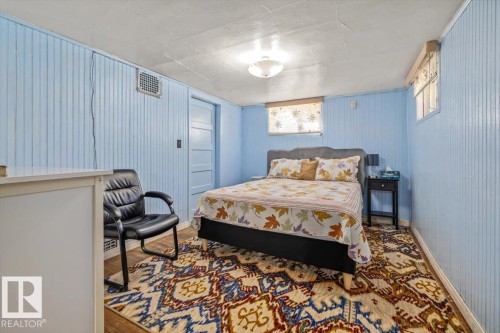 Room featuring light blue beadboard walls and a patterned area rug - 10939 96 Street, Edmonton, AB - Indoor Photo Showing Bedroom