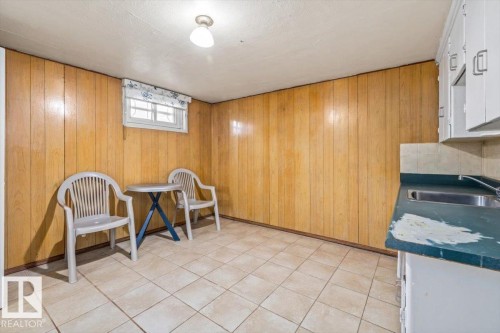 Room with wood-panel walls and light-colored tile flooring - 10939 96 Street, Edmonton, AB - Indoor Photo Showing Other Room