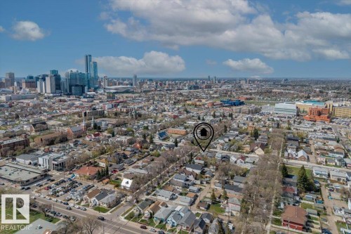 Aerial perspective showcasing a residential area with a prominent city skyline in the background - 10939 96 Street, Edmonton, AB - Outdoor With View