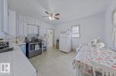 Bright kitchen featuring white cabinetry, light tile flooring, stainless steel range, light-toned countertops, and a ceiling fan - 10939 96 Street, Edmonton, AB  - Indoor Photo Showing Kitchen 