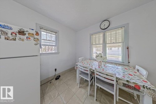 Bright dining area featuring tiled flooring and multiple windows with blinds - 10939 96 Street, Edmonton, AB - Indoor