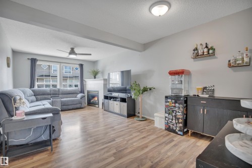 Living area with wood-finish flooring, a contemporary ceiling fan, and recessed lighting - 102 4415 South Park Drive, Leduc, AB - Indoor Photo Showing Living Room