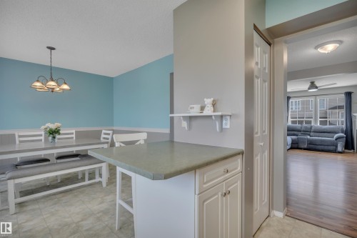 Dining area featuring light blue walls and a decorative chandelier - 102 4415 South Park Drive, Leduc, AB - Indoor