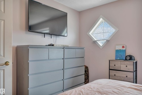 Light-colored wall paint complementing a diamond-shaped window - 102 4415 South Park Drive, Leduc, AB - Indoor Photo Showing Bedroom