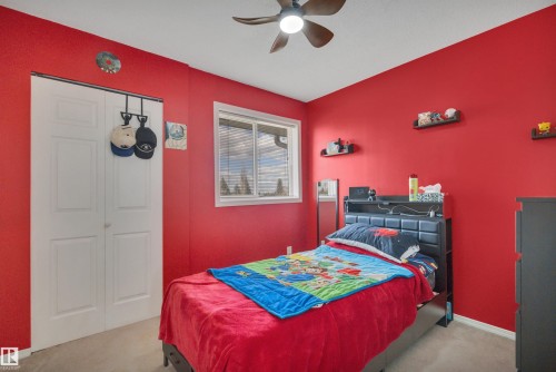 Room featuring a ceiling fan with integrated lighting, a window with blinds, and white bi-fold closet doors - 102 4415 South Park Drive, Leduc, AB - Indoor Photo Showing Bedroom