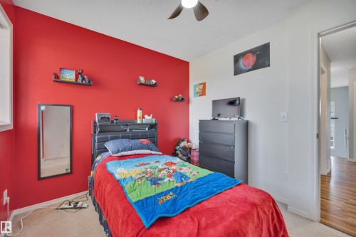 Carpeted room featuring a ceiling fan, window with blinds, and white trim - 102 4415 South Park Drive, Leduc, AB - Indoor Photo Showing Bedroom