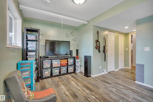 Versatile room featuring wood-finish flooring and recessed lighting - 102 4415 South Park Drive, Leduc, AB - Indoor