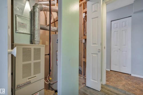 Utility area featuring a furnace and water heater installation - 102 4415 South Park Drive, Leduc, AB - Indoor