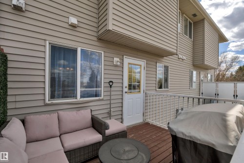 Outdoor deck featuring wood-finish flooring, white railing, and privacy screens - 102 4415 South Park Drive, Leduc, AB - Outdoor With Deck Patio Veranda With Exterior