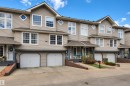 Multi-level townhome exterior featuring light beige siding and a dark gray trim - 102 4415 South Park Drive, Leduc, AB  - Outdoor With Facade 