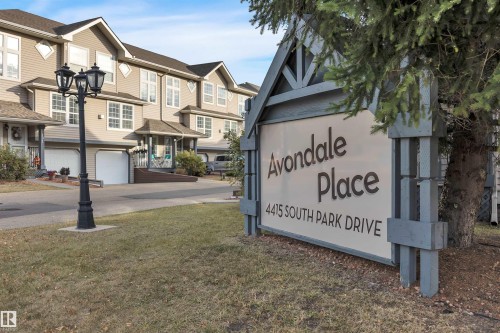 Avondale Place signage featuring a wooden frame and white paneling - 102 4415 South Park Drive, Leduc, AB - Outdoor