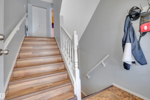 Staircase featuring wood-finish treads, white balusters, and a light gray wall color - 102 4415 South Park Drive, Leduc, AB - Indoor Photo Showing Other Room