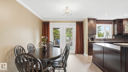 Kitchen and dining area featuring light wood-finish flooring, white crown molding, and recessed lighting - 27 Addison Crescent, St. Albert, AB - Indoor Photo Showing Dining Room