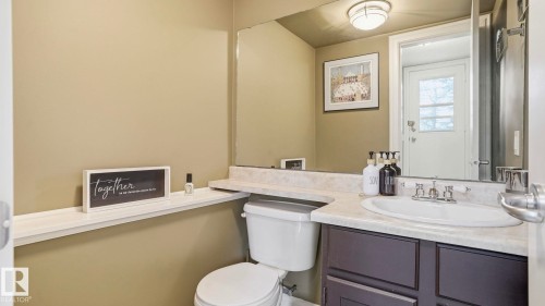Bathroom featuring a vanity with a light-colored countertop, an undermount sink, and a dark-finished cabinet - 27 Addison Crescent, St. Albert, AB - Indoor Photo Showing Bathroom