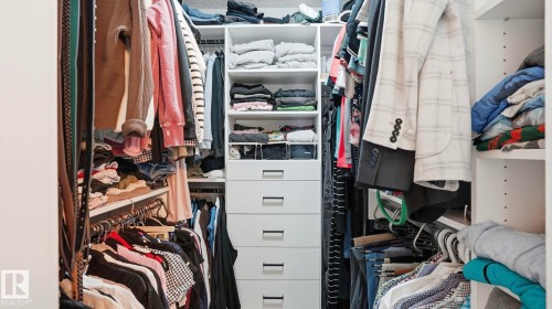 Custom closet system featuring built-in shelving, hanging rods, and integrated drawers - 27 Addison Crescent, St. Albert, AB - Indoor With Storage