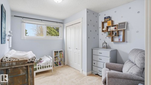 Carpeted room featuring a double-pane window, bi-fold closet doors, and light blue wall paint - 27 Addison Crescent, St. Albert, AB - Indoor Photo Showing Bedroom