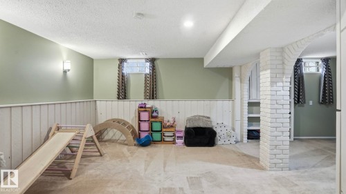 Carpeted room featuring light green walls, white wainscoting, and a textured white ceiling - 27 Addison Crescent, St. Albert, AB - Indoor Photo Showing Other Room