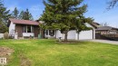 Front exterior featuring white siding, a brown shingled roof, and a two-car garage - 27 Addison Crescent, St. Albert, AB  - Outdoor With Deck Patio Veranda 