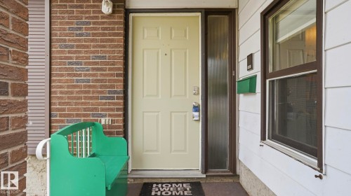 Cream-colored entry door with side light, featuring brick and horizontal siding exterior finishes - 27 Addison Crescent, St. Albert, AB - Outdoor With Exterior