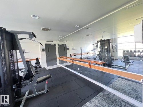 Dedicated fitness room featuring rubberized flooring, mirrored wall, recessed lighting, and wall-mounted barre - 710 2504 109 Street Nw, Edmonton, AB 